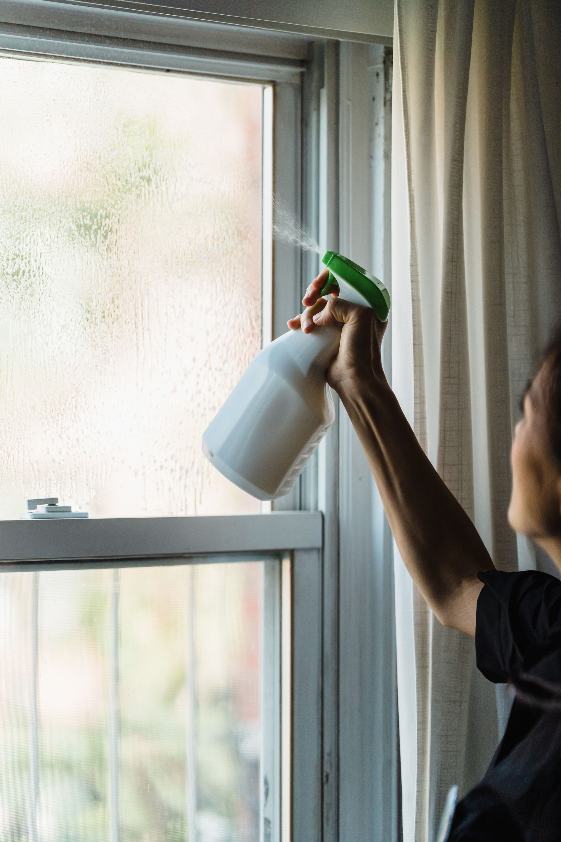 Reinigung eines Fensters mit Sprühflasche
